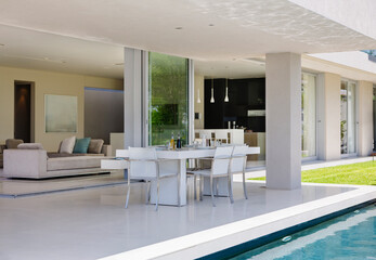 Set table on patio by pool of modern house