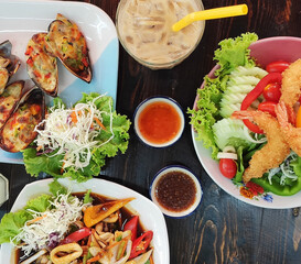 Flat lay food asia, Thailand with drink, with sauces on dark brown wood table, background. Eating top view. Cocktail, ice coffee with a straw.