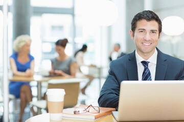 Businessman using laptop in cafe