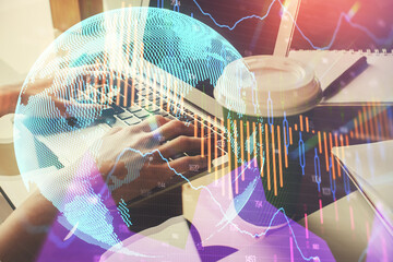 Double exposure of woman hands typing on computer and forex chart hologram drawing. Stock market...