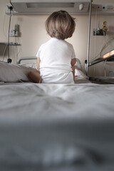 Baby girl sitting on a hospital bed waiting