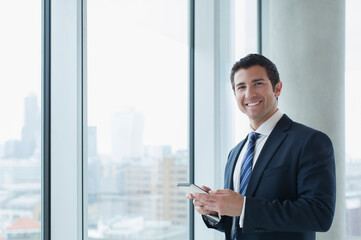 Businessman using cell phone in office