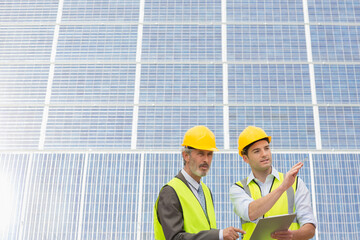 Workers examining solar panels in rural landscape