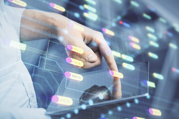 Double exposure of man's hand holding and using a digital device and data theme hologram drawing. Technology concept.