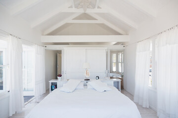 Fototapeta na wymiar Rafters above bed in white bedroom