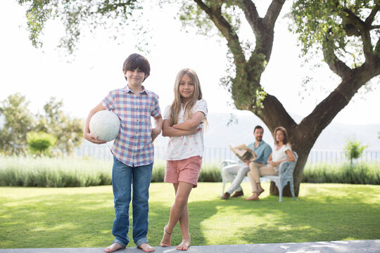 Brother And Sister With Volleyball In Backyard