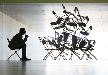 Businessman viewing office chair installation art