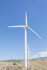 Fototapeta na wymiar Wind turbines spinning in rural landscape