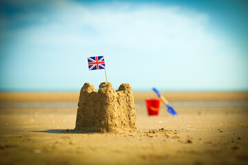 British flag in sandcastle on beach
