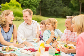 Multi-generation family enjoying lunch in backyard