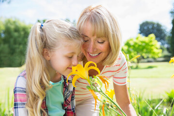 Grandmother and granddaughter smelling flowers