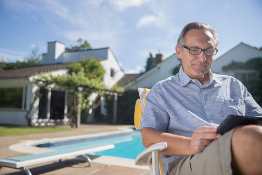 Man using digital tablet at poolside