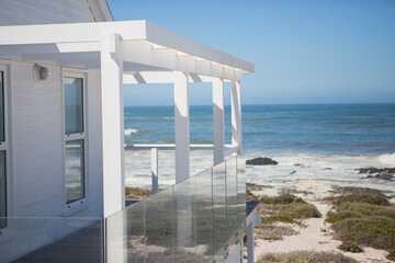 Beach house and balcony overlooking ocean - obrazy, fototapety, plakaty