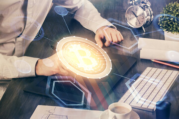 Double exposure of man's hands holding and using a phone and crypto currency blockchain theme drawing.