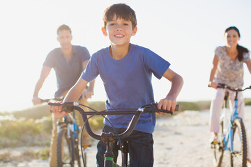 Family riding bicycles on sunny beach