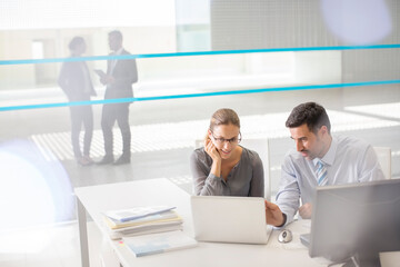 Business people working at laptop in office