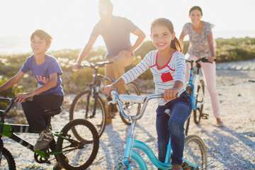 Family riding bicycles on sunny beach