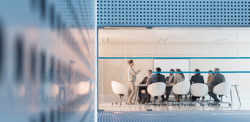 Businesswoman leading meeting in modern conference room