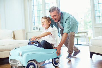 Father pushing son in toy car