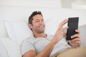 Man using digital tablet in bed