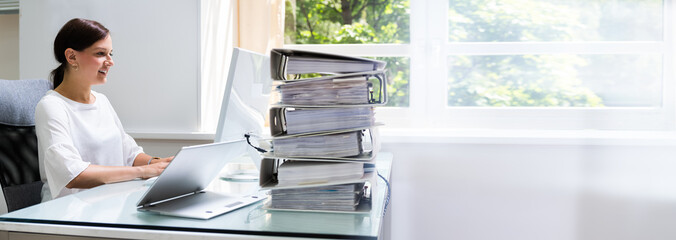 Businesswoman Working At Office With Stack Of Folders