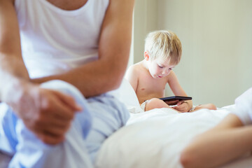 Obraz na płótnie Canvas Boy using digital tablet on bed