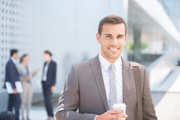 Portrait of confident businessman with coffee outdoors