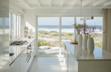 Modern white kitchen with ocean view - obrazy, fototapety, plakaty
