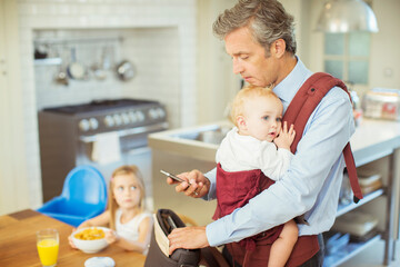 Father with baby packing bag for work