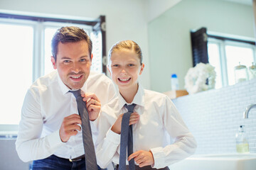 Obraz premium Father and daughter adjusting ties in bathroom
