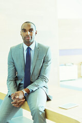 Businessman sitting on desk in office