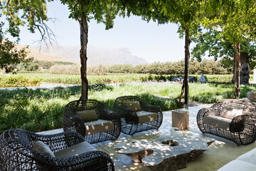 Armchairs and sofa on modern patio overlooking vineyard