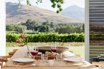 Dining table and chairs on luxury patio overlooking vineyard