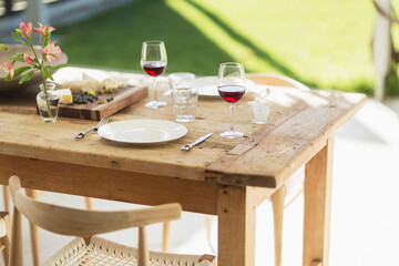 Wine and appetizer on wooden dining table on patio