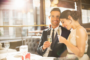 Well-dressed couple drinking champagne in restaurant
