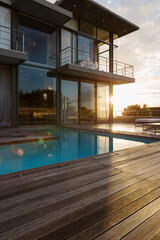 Fototapeta premium Sun behind luxury house with swimming pool