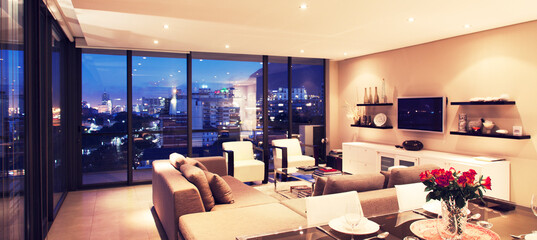 Illuminated modern living room overlooking city