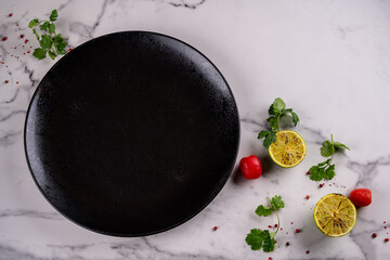 Black empty plate on marble, flatlay - stylish tableware, table decor and food menu concept. Serve the perfect dish