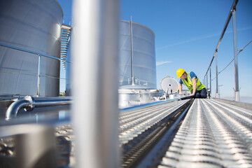 Worker on platform looking down into milk tanker