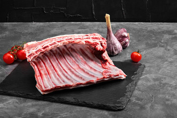 Organic lamb meat on the ribs. Fresh meat on the bone. copy space, gray background.