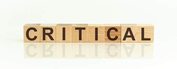 critical word written on wood block. critical text on table, concept.