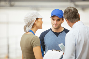 Supervisor and workers talking in food processing plant