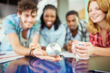 People examining globe in office