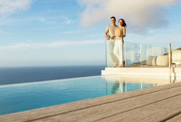 Couple on modern balcony overlooking ocean