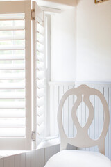 Chair by window with wooden blinds