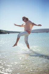 Woman splashing in water on beach 