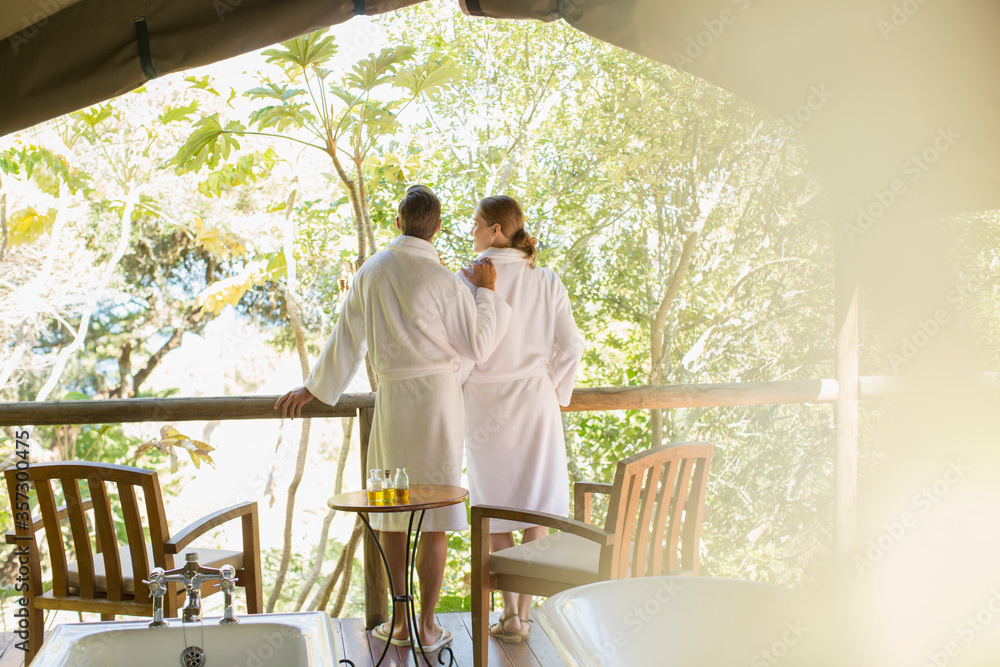 Wall mural couple in bathrobes standing in outdoor spa