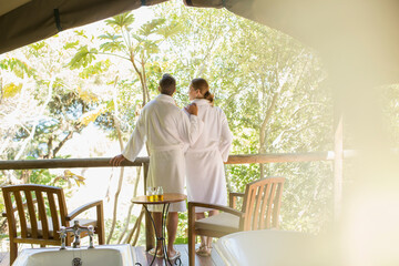 Couple in bathrobes standing in outdoor spa