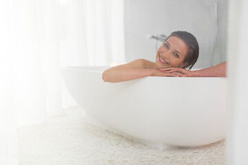 Smiling woman taking bath in modern bathroom