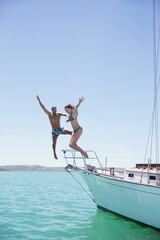 Couple jumping off boat into water 